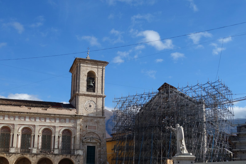 Il palazzo comunale e i resti della basilica di San Benedetto nell'omonima piazza a Norcia.